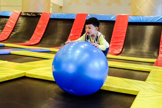 原来这里的蹦床太刺激了,小朋友意犹未尽的玩耍著,开心的抱起瑜伽球东
